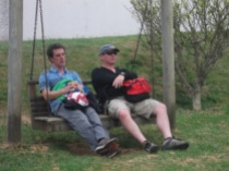 Two tired men, letting the children run off their energy in the playground